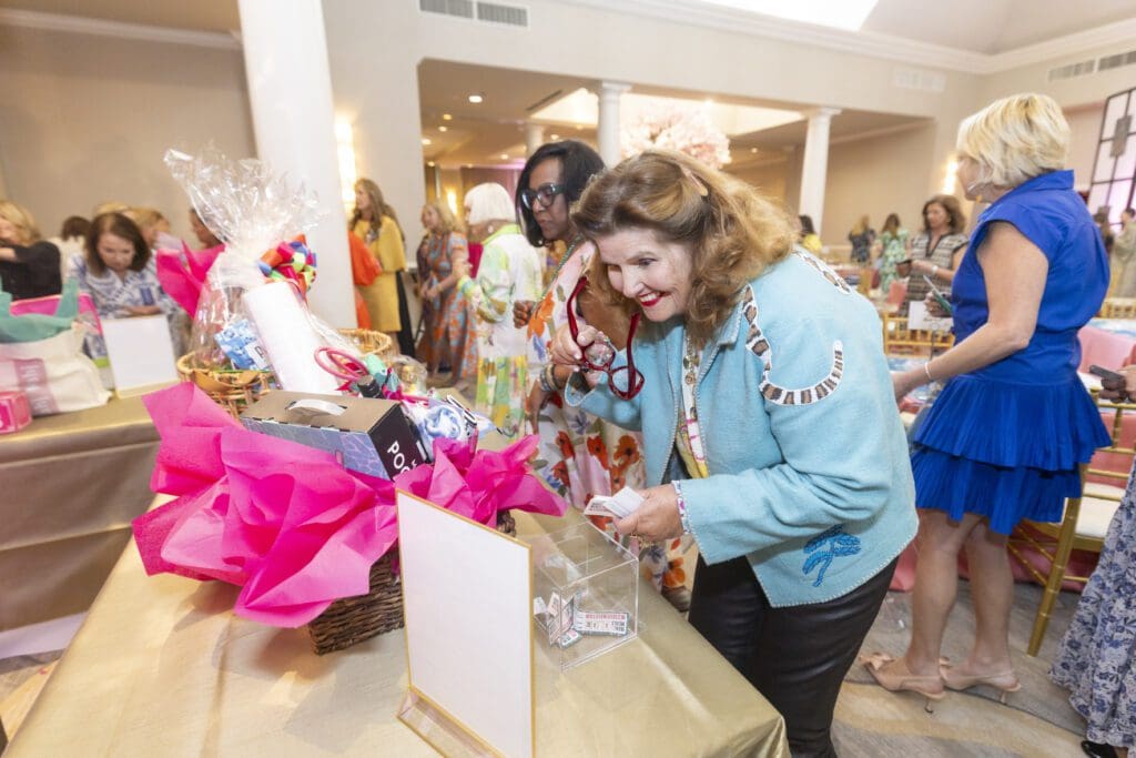 Marian Brown known as Mahjong Marmee admiring her raffle contribution (Photo by Sharon Ellman, Ellman Photography)