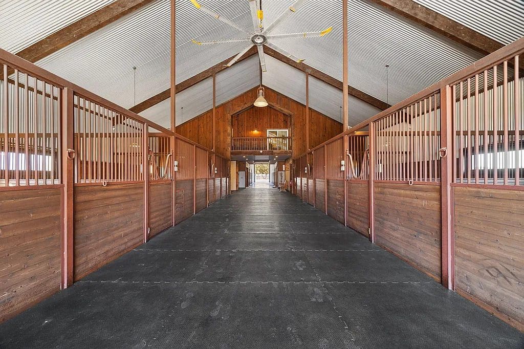 The eight-stall barn includes oversized foaling stalls, tack and feed rooms, and extended runs for every horse. (Courtesy)