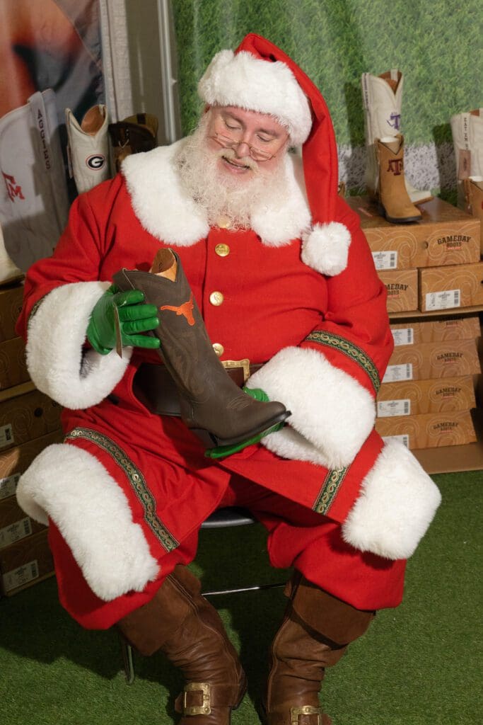 Santa Claus eyes a new pair of cowboy boots. (Photo by George Fiala)