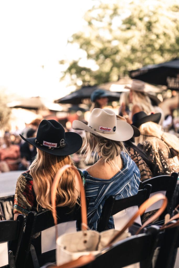 Guests in wide-brim hats watched from the front row, trading smiles and snapshots as the runway came to life. (Photo by Avin Park Photography)