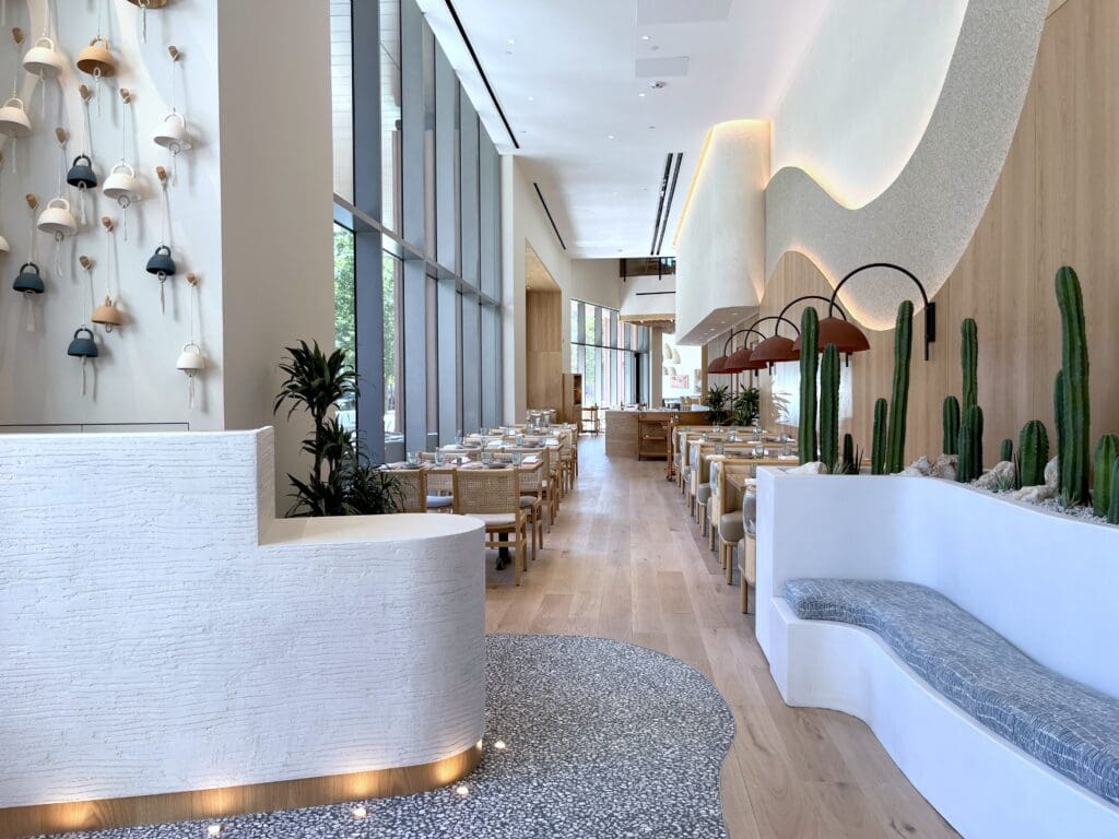 The 7,000-square-foot, two-story space was designed by Christina Wilburn of Gin Design Group. The interiors channel the warmth of Baja with wide-plank oak flooring and sculpted wood baffles that echo the movement of gentle ocean waves. Custom touches include a hand-finished mural of the Pacific coastline and banquettes upholstered in sun-washed terracotta and azure-blue hues. (Photo by Paula Murphy)