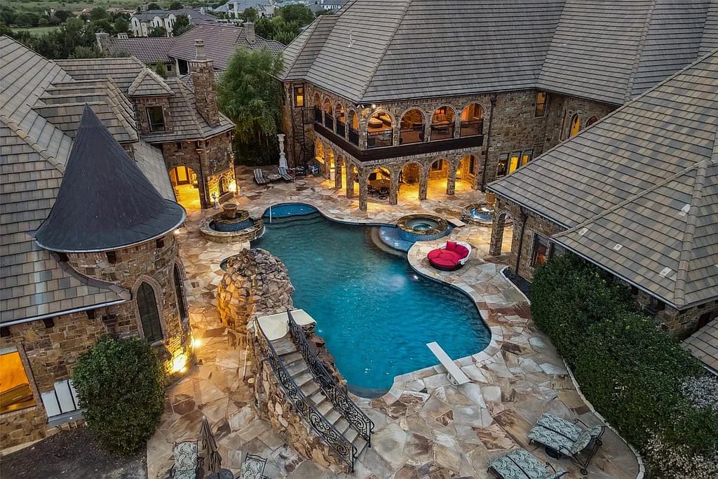 The estate’s outdoor pool features a slide, diving platform, and outdoor seating. (Courtesy)