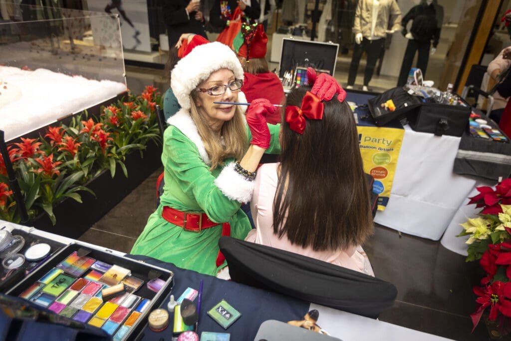 A young guest receives festive face painting. (Photo by Kim Gleason)
