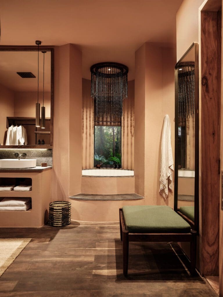 The bathroom’s deep soaking tubs and warm rain showers look directly out onto the surrounding greenery.