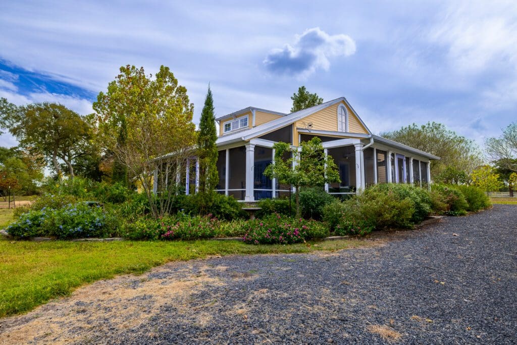 The farmhouse at 3100 Trails End in Brenham anchors 20 acres of beautifully landscaped terrain.  (Photo by Courtesy of Nan & Company Properties)