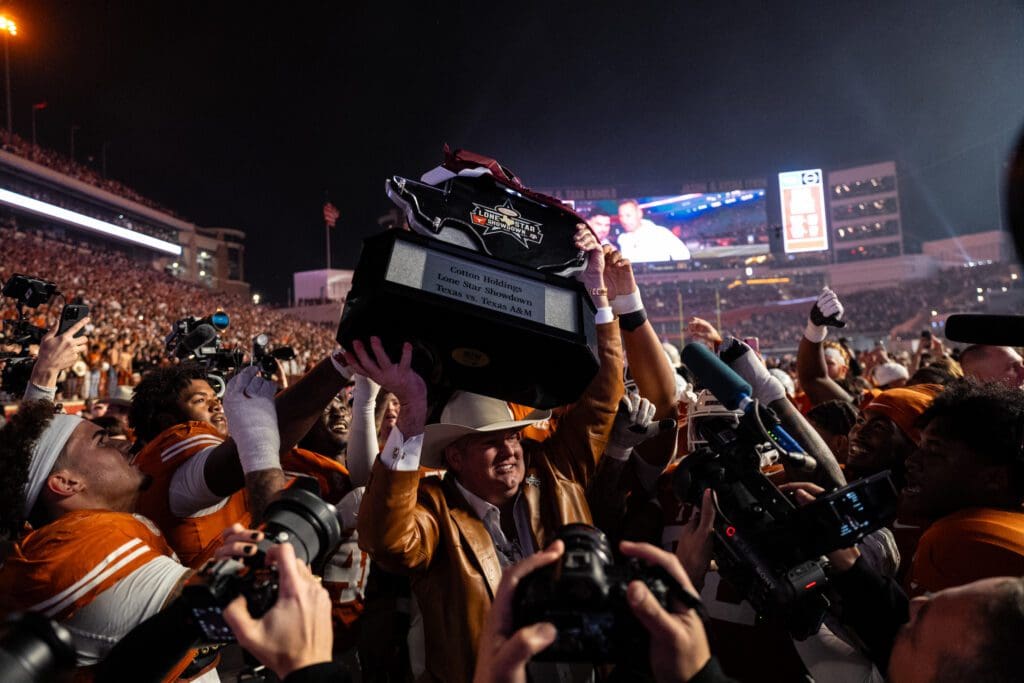 Cotton Holdings founder and chairman Pete Bell carries the Lone Star Showdown trophy to the winning Texas Longhorns (Photo Courtesy of Cotton Holdings) (Photo by Courtesy of Cotton Holdings)
