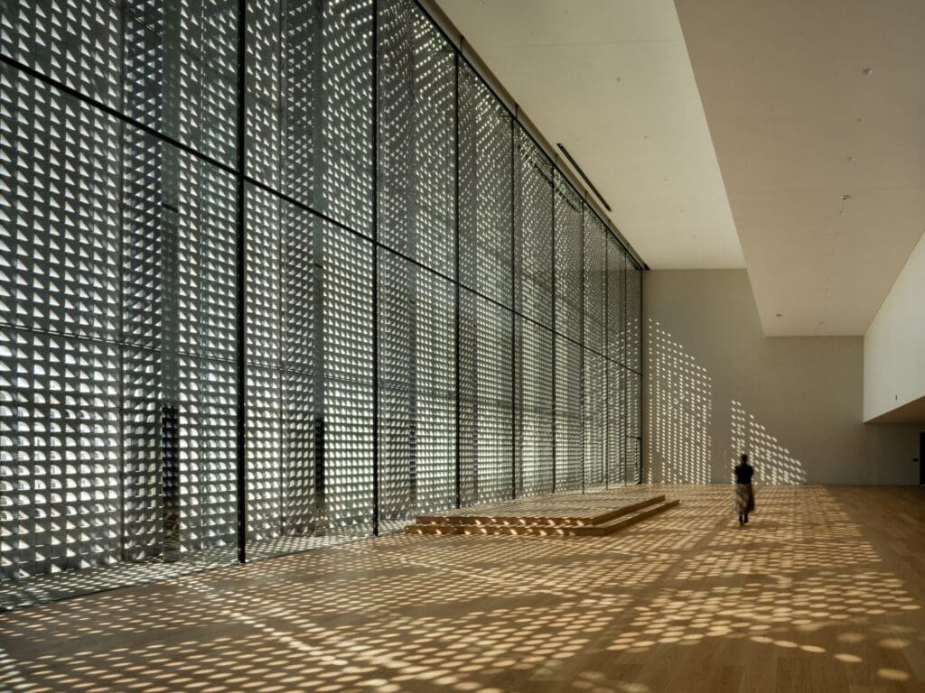 Natural light filters into the Social Hall through the expansive stone screen of the Ismaili Center, Houston’s façade (Photo by Nic Lehoux)