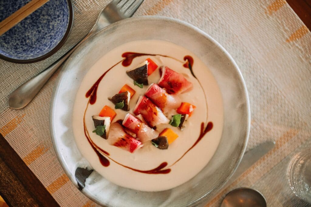 The cold-smoked hamachi crudo with Tom Kha, charred shiitake, and papaya was our favorite dish at Norman's. (Courtesy)