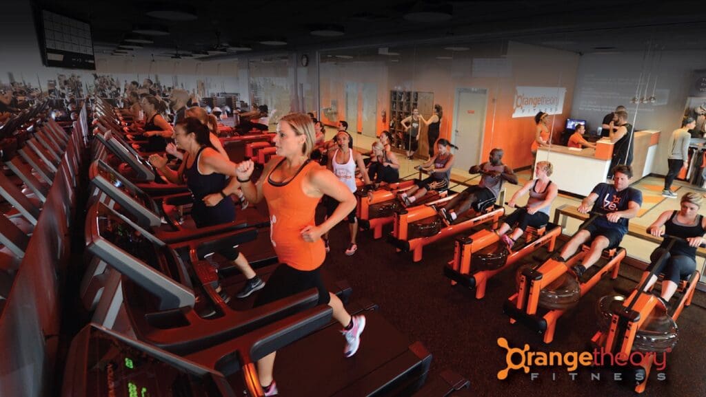 Participants move through a structured Orangetheory Fitness workout that combines treadmill intervals, rowing and strength training in a coach-led, heart rate-based class. (Photo courtesy Orangetheory Fitness)