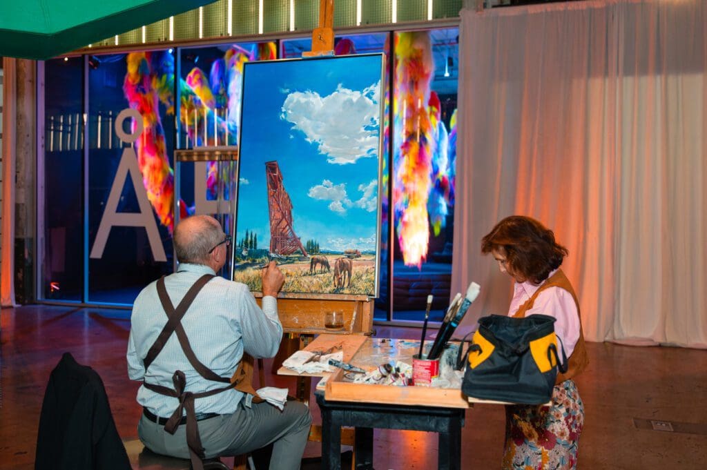 Ucross alumn artist Don Stinson paints a western landscape during the Ucross gala
