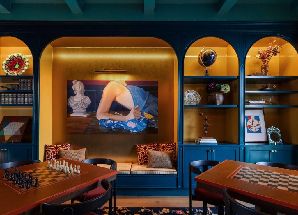 The library is painted high-gloss blue and marigold. Artwork Kelli Vance's "Separation Anxiety," 2019. (Photo by Julie Soefer)