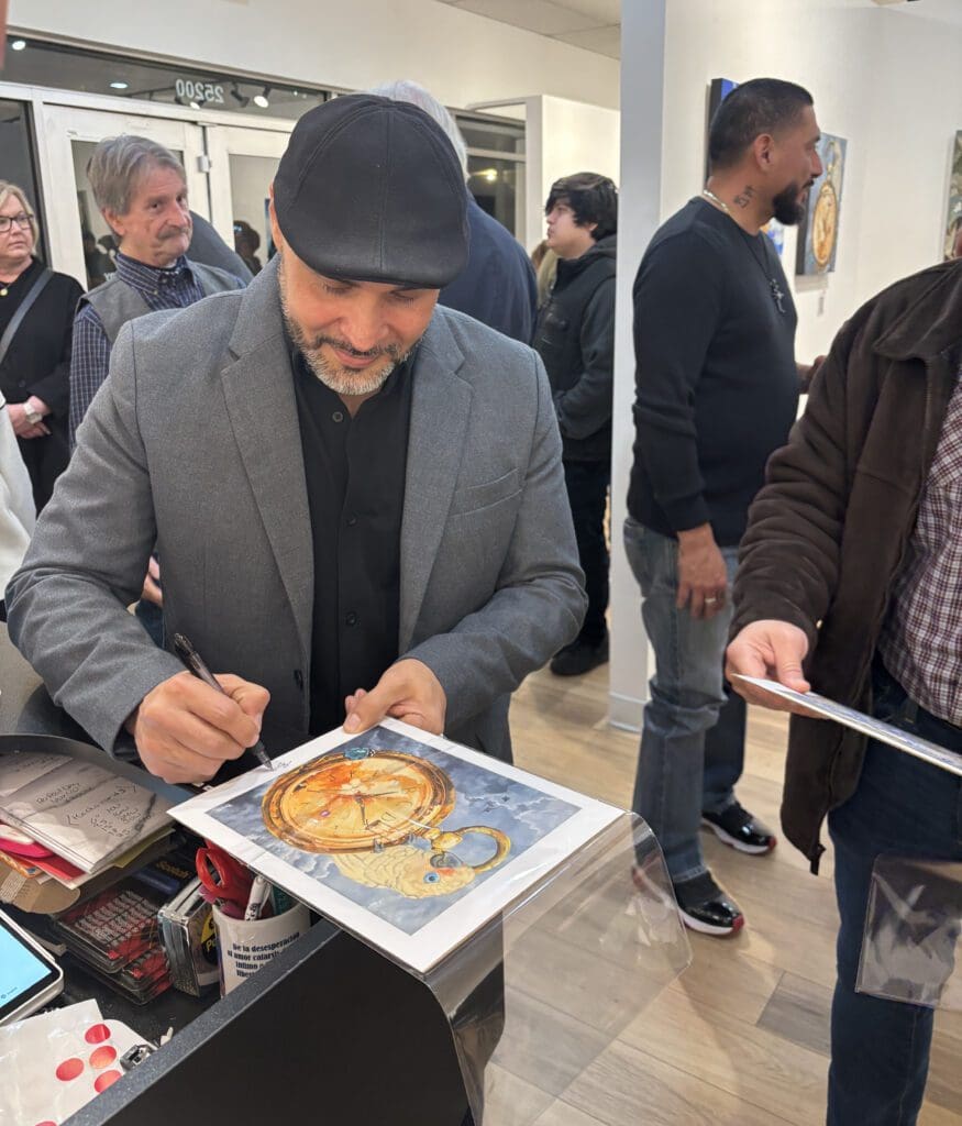 Cruz signed limited edition prints at the opening of his solo show. (Photo by Laura Landsbaum)