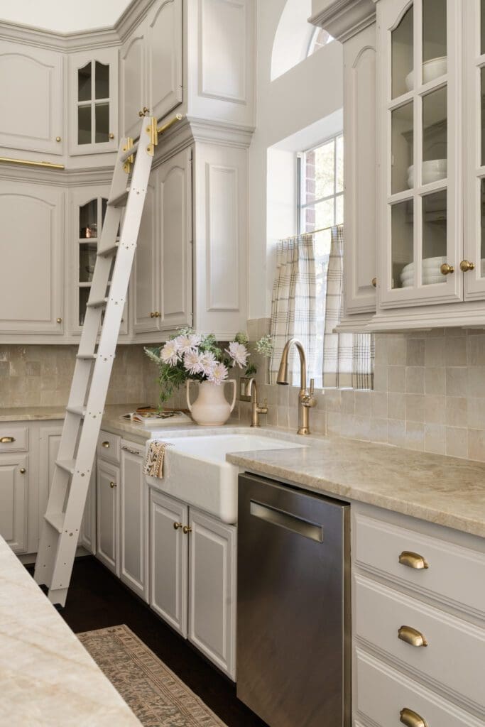 The Tiny Haven Design team swapped in cafe curtains for heavy shutters, and added a new sink while keeping the countertop. (Photo by Madeleine Harper Photography)