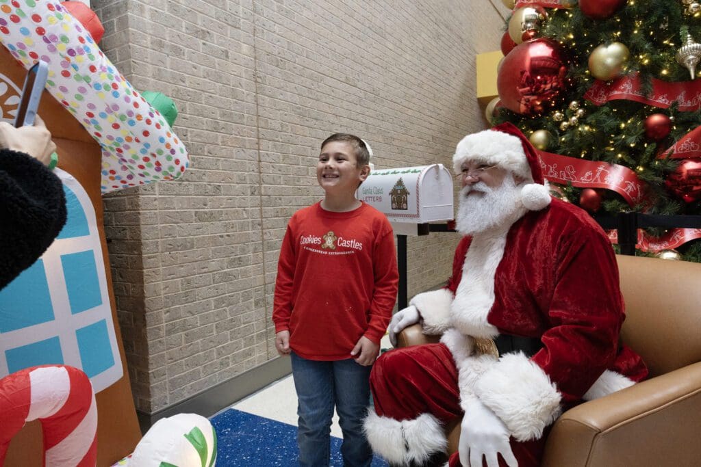 Maxwell Frank poses with Santa Claus (Photo by Allison Slomowitz - Photographer, Scottish Rite for Children)