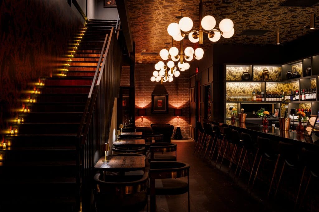 When you enter the building, Night Rooster's bar is on the right and a staircase leading up to The Saint on the left. (Photo by Samantha Marie Photography)