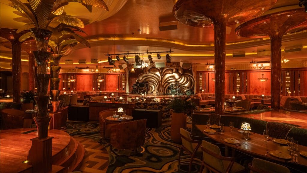 A large main stage is adorned with "Austrian curtains, plus three dedicated performance platforms surrounded by Delilah’s iconic golden palm trees for a larger-than-life experience." (Photo by Robert Tsai)