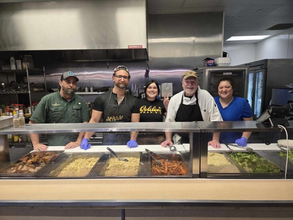 Kirk Oldham (second from left) joins fellow chefs and cooks to bring meals to those in need through his nonprofit. (Courtesy)
