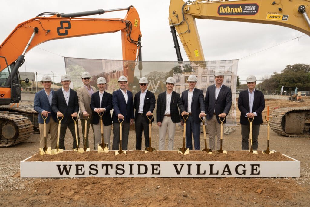 Developers and partners tied to the Westside Village project gather before a large excavation site. (Photo courtesy of George Fiala)