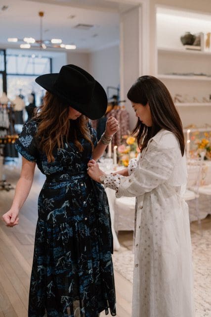 Designer Christy Lynn adjusts Courtney Wilkerson's dress as she wears a piece from the designer's Western capsule. (Photo courtesy Kelsey Horner)