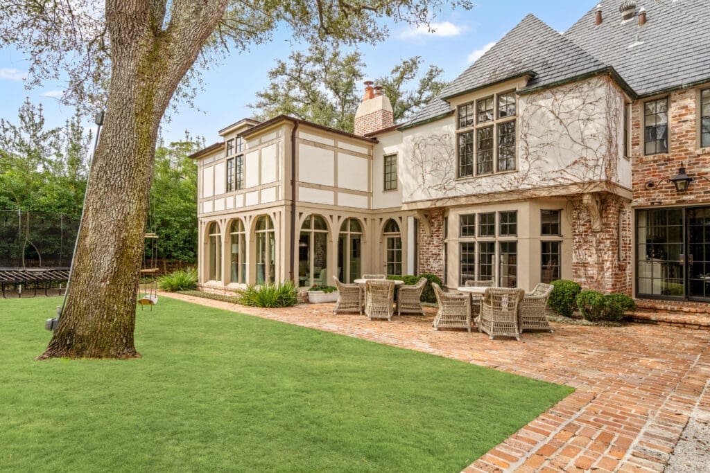 A beautifully scaled backyard anchored by a stately mature oak, offering a picturesque backdrop to the home’s refined architecture (Photo by Sonya Bertolino / Compass)