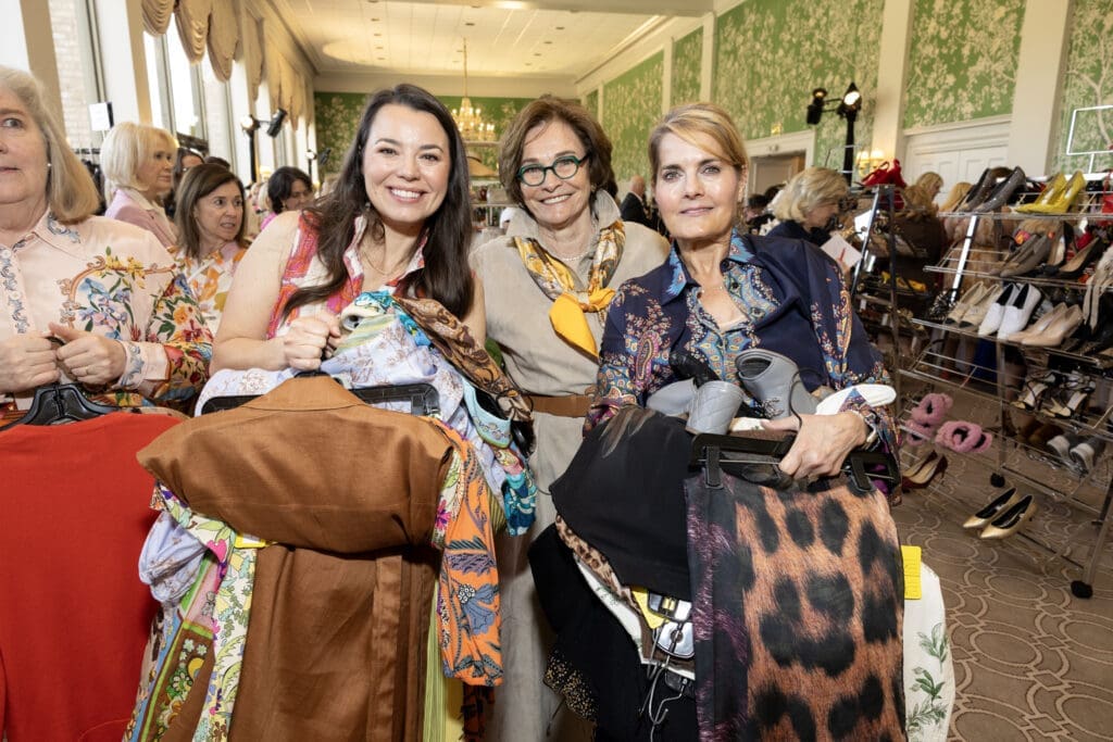 Fashionable ladies scoop up armloads of gently used/brand new clothing at the Salvation Army Auxiliary Reflections on Style luncheon