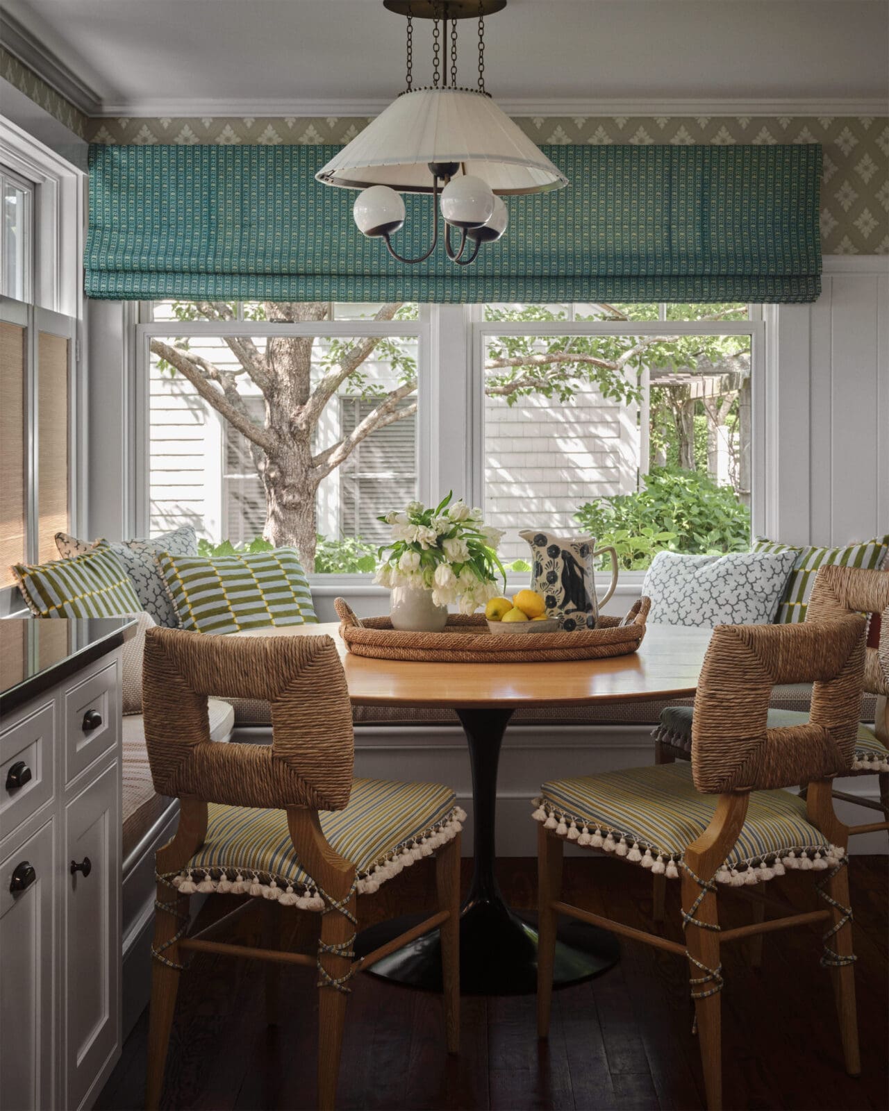 The breakfast-nook chairs from Hollywood at Home, L.A., are covered in Pierre Frey performance fabric. Farrow & Ball wallpaper. Pillows in a Schumacher block print and performance fabrics. RTO Lighting pendant light. (Photo by Douglas Friedman)