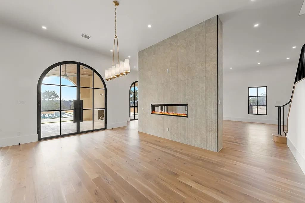 A double-sided linear fireplace subtly divides the home’s open-concept living and dining spaces. (Courtesy)