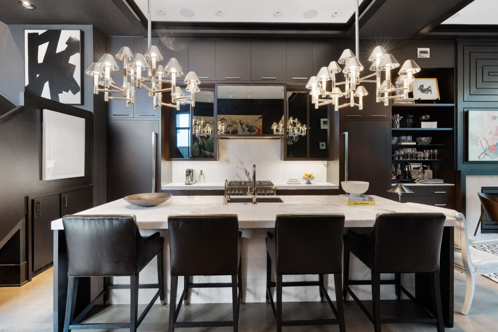 The kitchen is anchored by a substantial island with counter seating, gas cooking, and beautul lighting, (Photo by Aria Media)