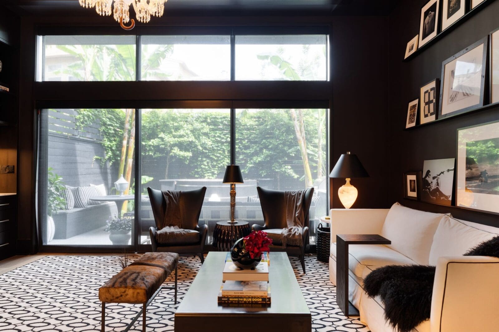 A wall of windows frames the landscaped backyard while elevated ceilings, built-ins, and a fireplace bring scale a (Photo by Aria Media)