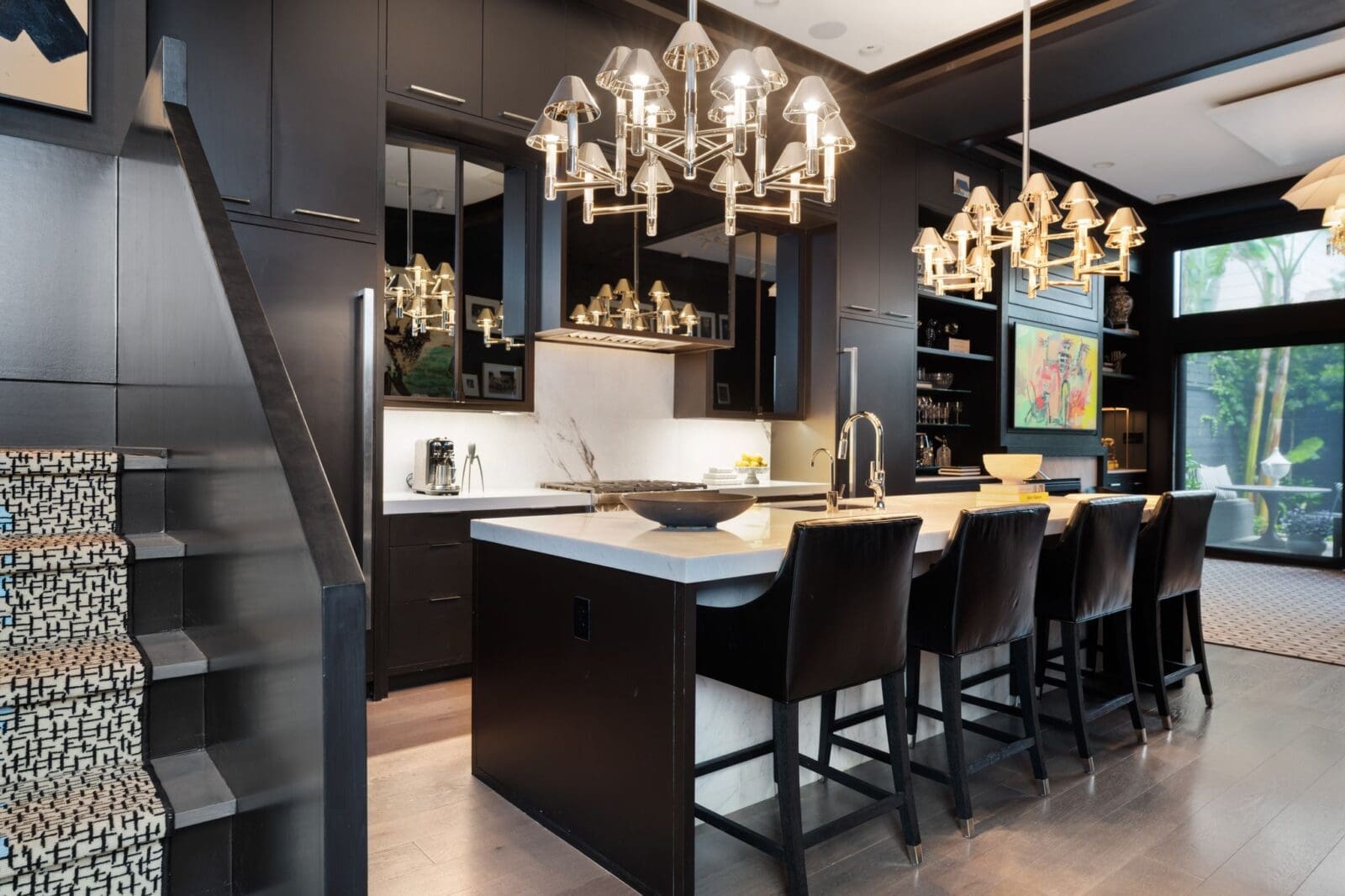 From the entry, sightlines extend across the open-concept layout, where architectural stairs, a generous island with counter seating, and expansive volume define the heart of the home at 2117 Elmen St. (Photo by Aria Media)