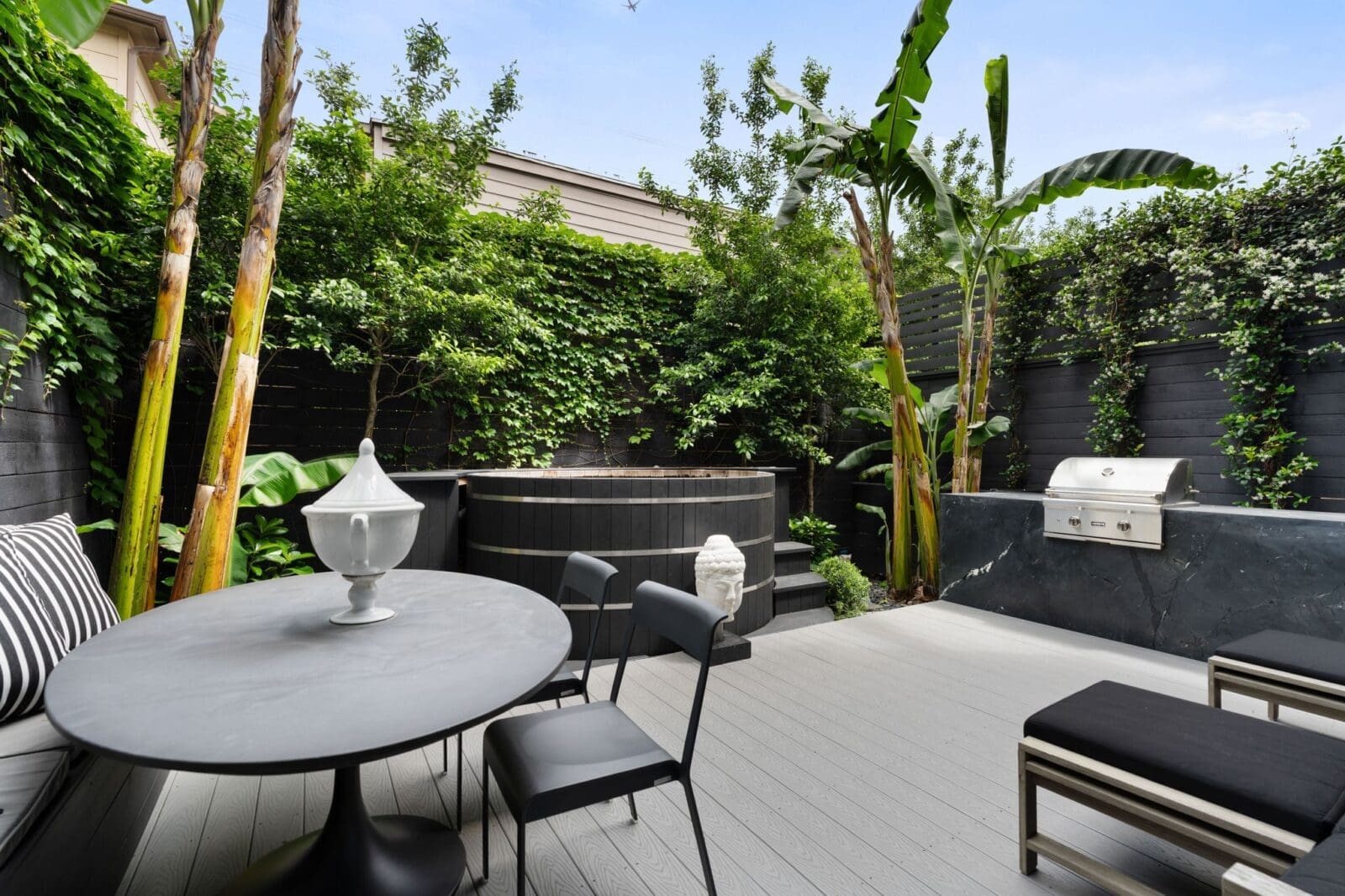The Japanese soaking tub is surrounded by layered greenery and professionally designed landscaping (Photo by Aria Media)