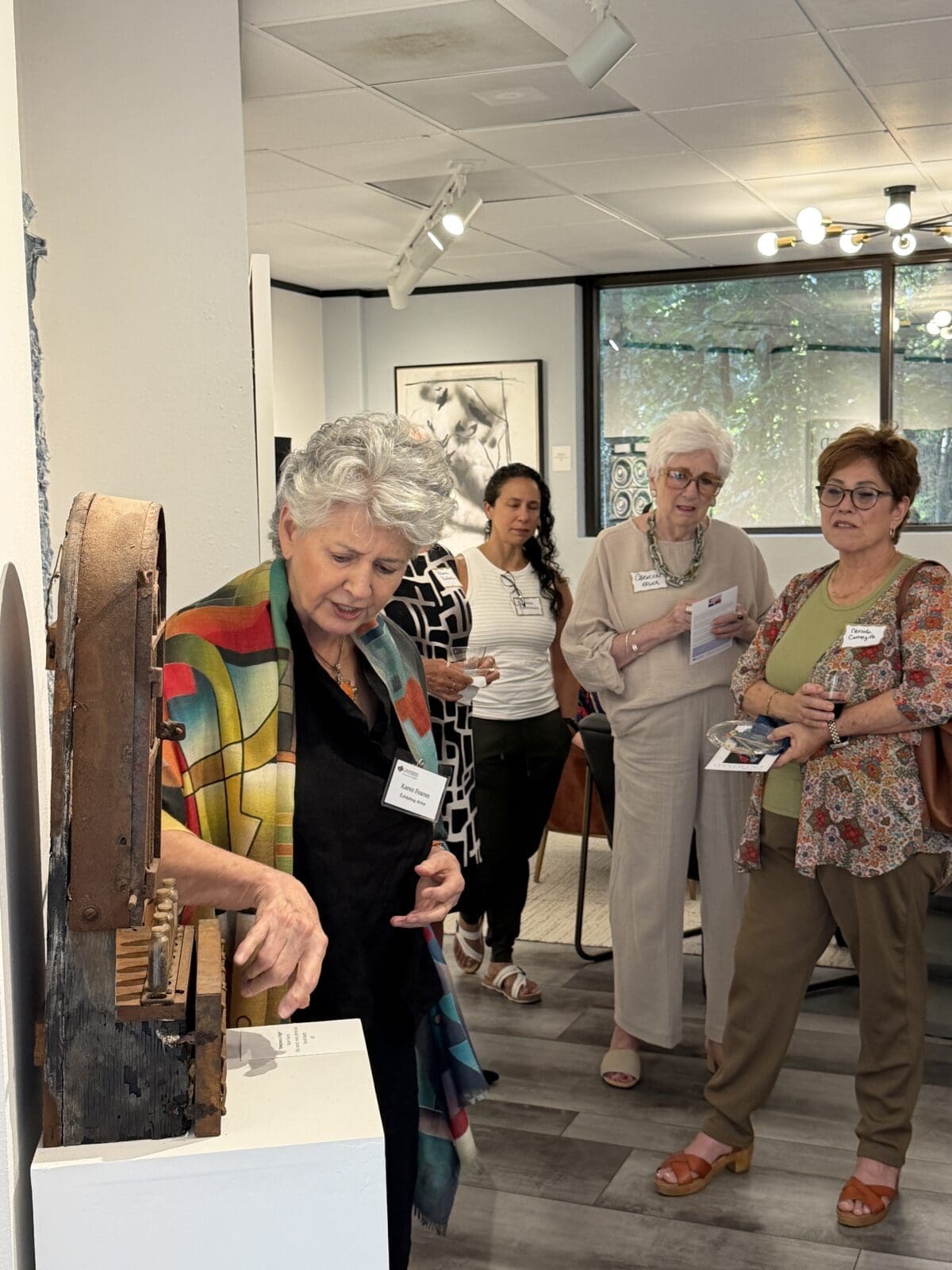 Exhibiting Artist Karen Fearon explains the significance of her piece. (Photo courtesy of The Woodlands Art Council)