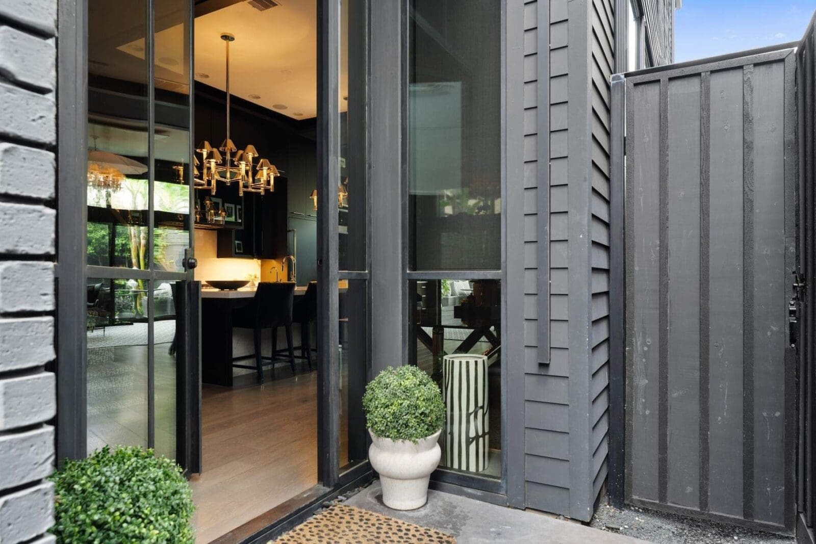 Steel-framed doors open into a dramatic main living space where elevated ceiling heights and natural light immediately set the tone for this design-forward Houston residence. (Photo by Aria Media)