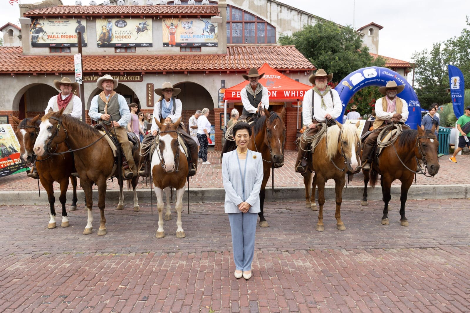 Princess Takamado poses in front of the Fort Worth Herd during her Stockyards visit. (Photograph by Brooks Burris for Visit Fort Worth)