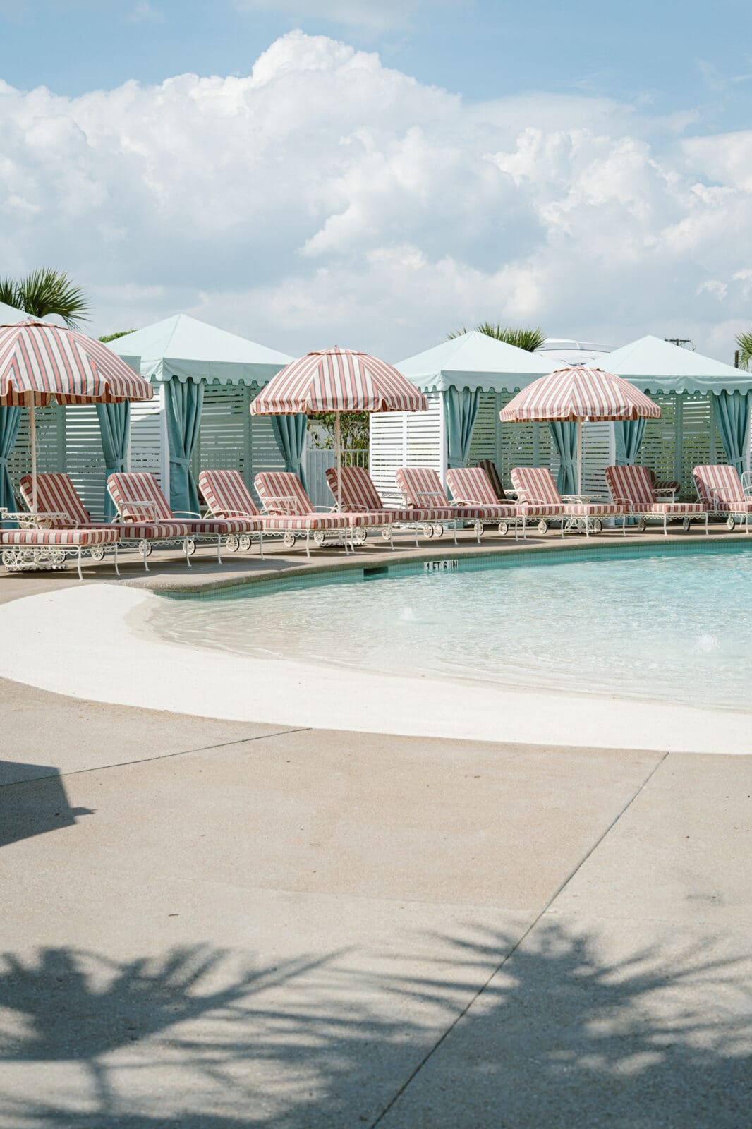Striped loungers, private cabanas, and a beach-entry pool create a resort-style escape at Caravan Court Hotel. (Courtesy)