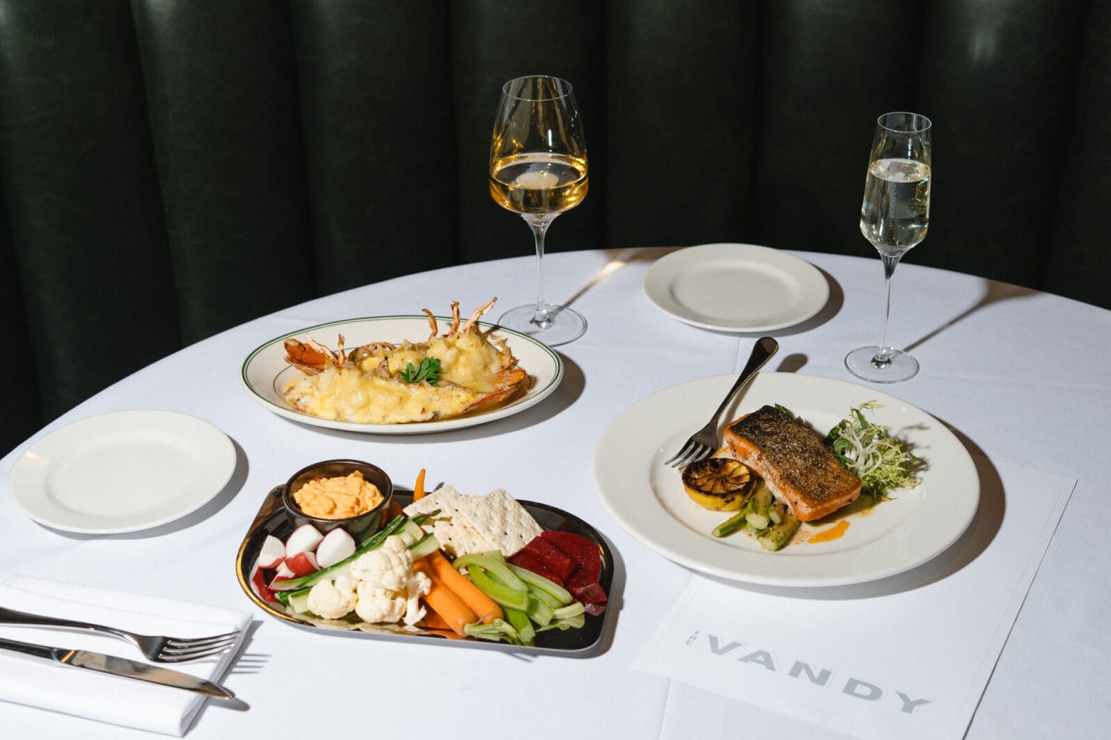 The Vandy serves dishes including lobster thermidor, pan-seared salmon, and a seasonal crudité platter inside Caravan Court Hotel. (Courtesy)